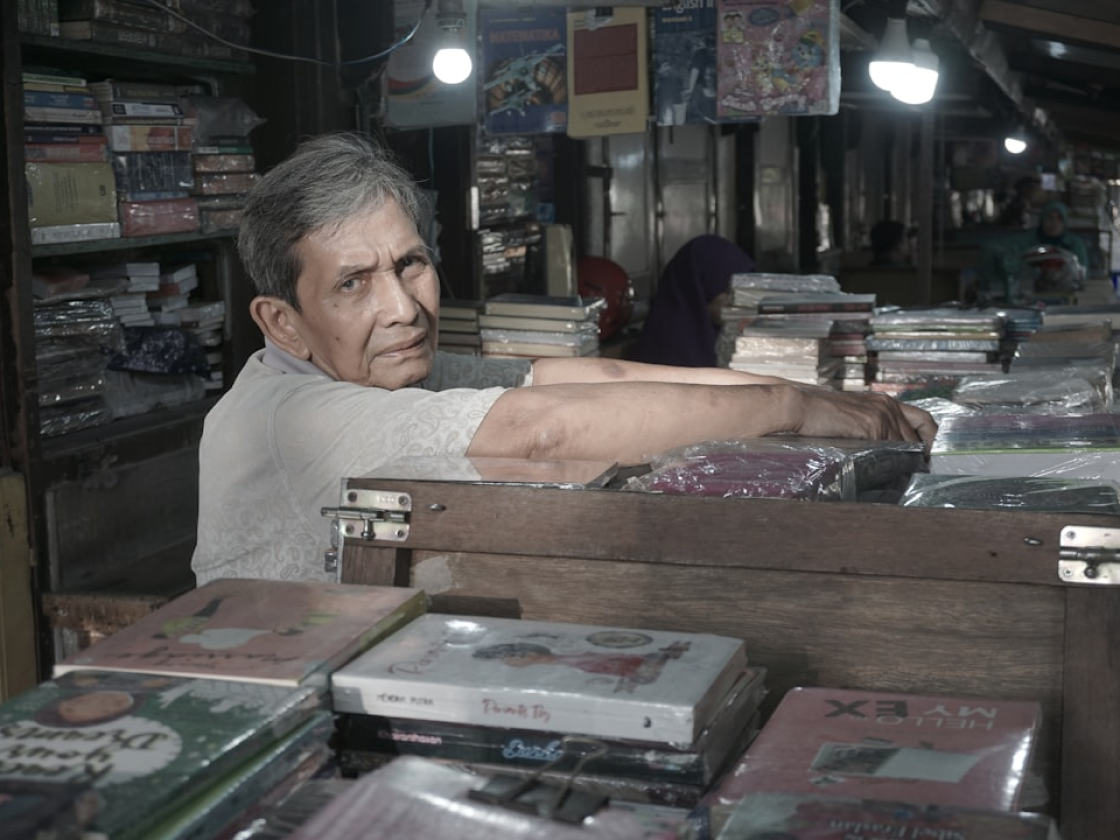 Merchant in traditional shop with vinyl records and goods